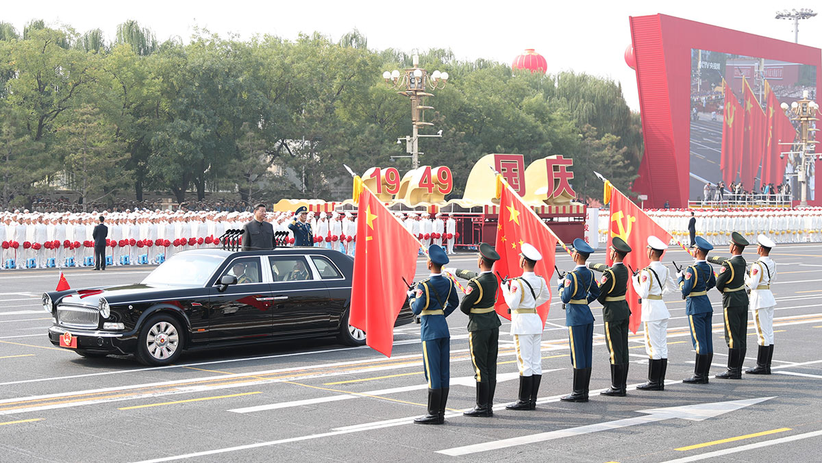 習(xí)近平驅(qū)車行進(jìn)至黨旗、國旗、軍旗前，向旗幟行注目禮